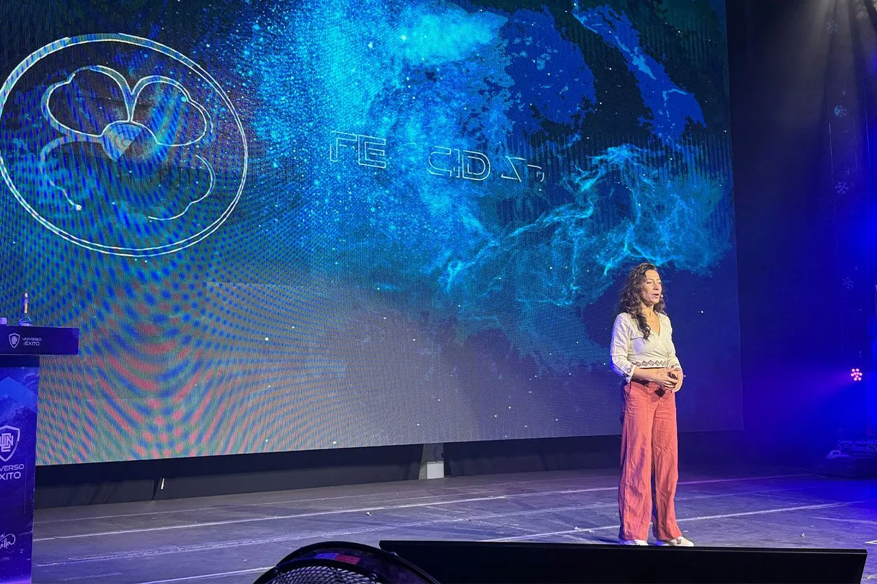 Sara Tau dando una charla sobre el Método TAU en un escenario